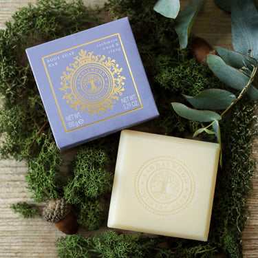 Bar of soap and its packaging on a natural background with greenery