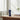 RHS body wash bottle on a wooden surface with white towels and flowers in the background