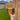 Hand holding an RHS soap bar in front of a wooden fence and grassy area