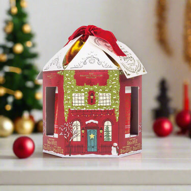 Christmas-themed gift box with a house design on a white background